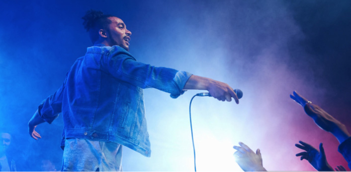 Un cantante en un escenario dando un concierto.