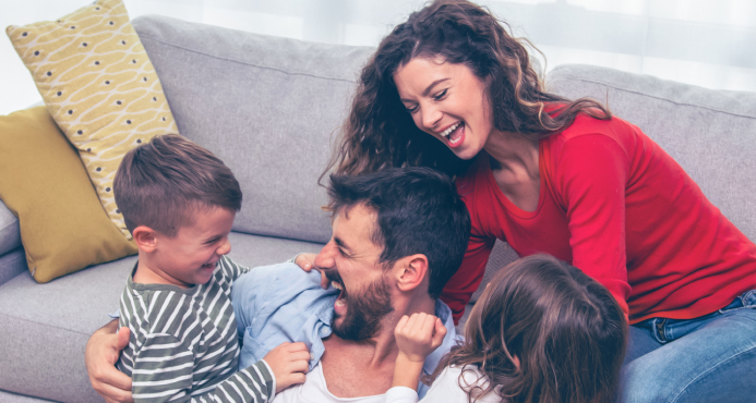 Una familia feliz riendo y jugando juntos en la sala de estar.