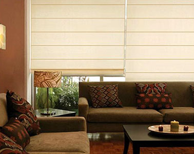 Persiana romana beige en sala moderna con sillones cafés y mesa de centro.
